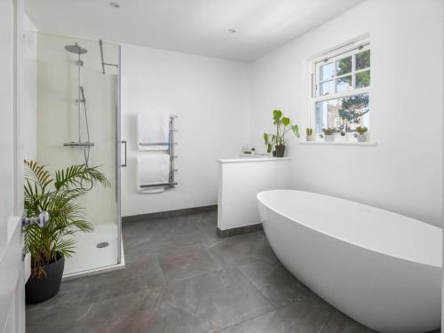 a white bathroom with a tub and a sink at 5 Bed in Bude oc-85698 in Poughill