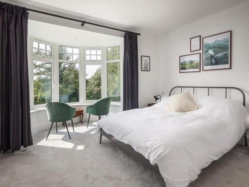 a bedroom with a bed and a desk and windows at 5 Bed in Bude oc-85698 in Poughill