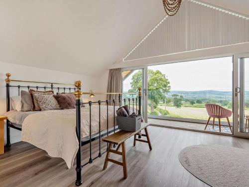 a bedroom with a bed and a large window at 5 Bed in Denbigh oc-86009 in Llandyrnog