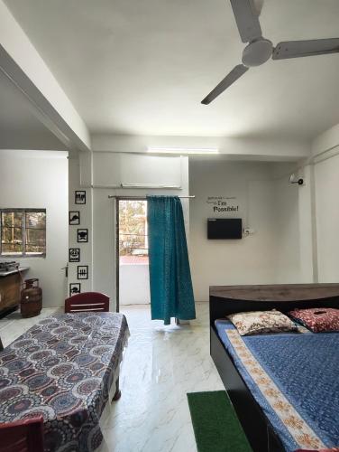 a bedroom with two beds and a ceiling fan at Green leaf homes in North Lakhimpur