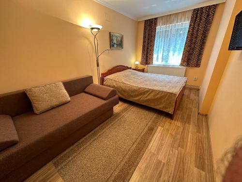 a living room with a couch and a bed at Horváth Apartmanház in Orosháza