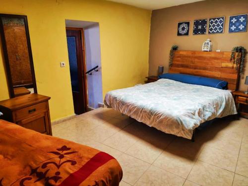 a bedroom with a large bed and yellow walls at Casa Serrana in Quesada
