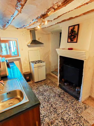 a kitchen with a fireplace and a sink and a stove at Casa Serrana in Quesada