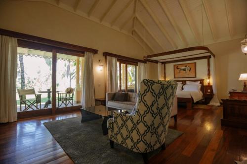 a bedroom with a bed and a chair in a room at Ocean Beach Resort & SPA in Malindi