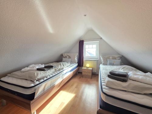 two beds in a room with a attic at Ferienwohnung Südwind Norddeich in Norden