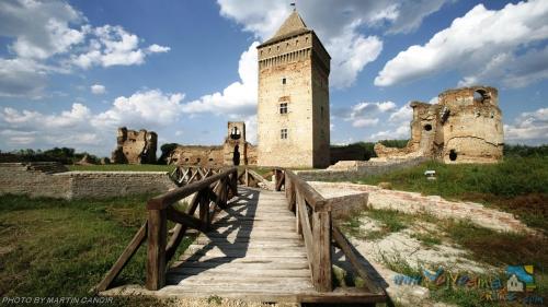 un puente de madera que conduce a un castillo antiguo en Pansion Jakić, en Bač