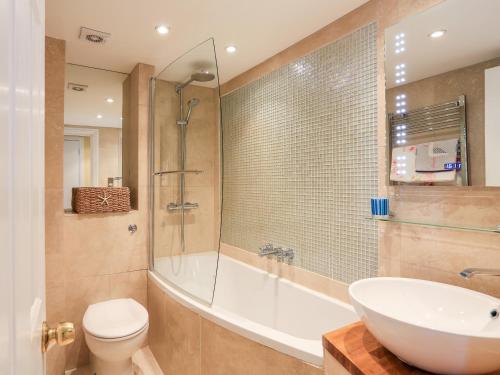 a bathroom with a tub and a toilet and a sink at 3 Dartview in Dartmouth