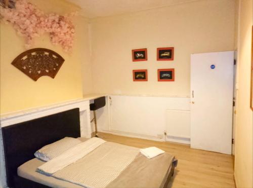 a bedroom with a bed and a wall with pictures at Central Simple Cambridge stay in Cambridge