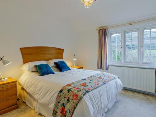 a bedroom with a large bed with two blue pillows at 6 Bed in Abergele oc-91054 in Llanddulas