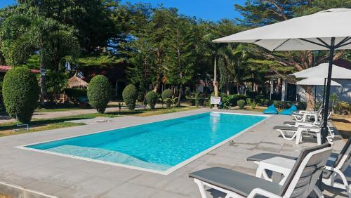 a swimming pool with chairs and an umbrella at Matcha Lanta Resort in Ko Lanta