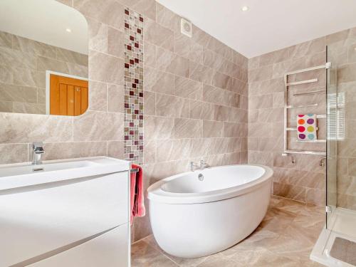 a bathroom with a white tub and a sink at 2 Bed in Cromer oc-29556 in Cromer