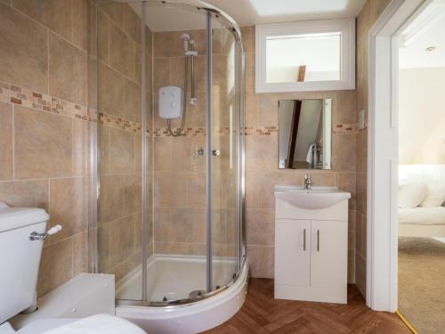 a bathroom with a shower and a toilet and a sink at 5 Bed in Aberystwyth oc-58889 in Llanrhystyd