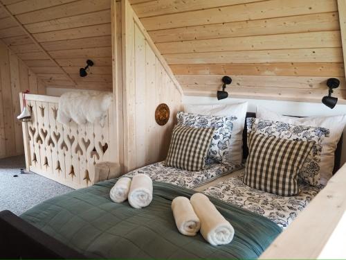 a room with a bed with pillows and a crib at Owczarnia Tatry in Bukowina Tatrzańska