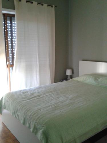 a bedroom with a white bed and a window at Apartamento Fonte Luz II in Matosinhos