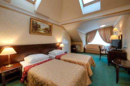 スタルガルトにあるドウォレク ヘットマンスキのベッド2台とテレビが備わるホテルルームです。