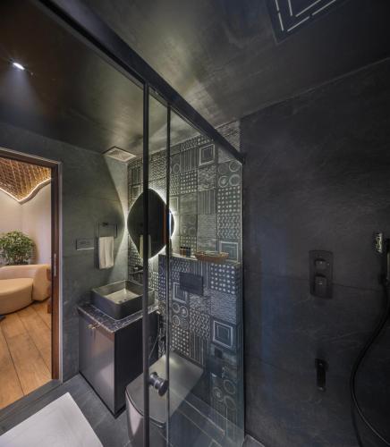 a bathroom with a glass shower and a sink at Monticle Glamps in Vagamon