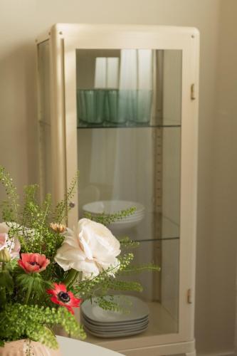 a reflection of a glass cabinet with plates and flowers at JETHON Appartement in der Gasse 2 in Grimschleben