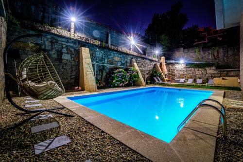 a swimming pool at night with a swing at Villa Hermida in Sanxenxo