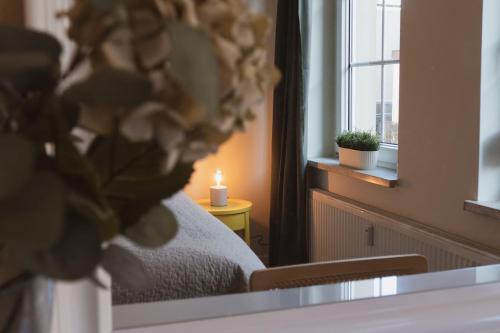 a bedroom with a bed with a candle and a window at JETHON Appartement in der Gasse 2 in Grimschleben
