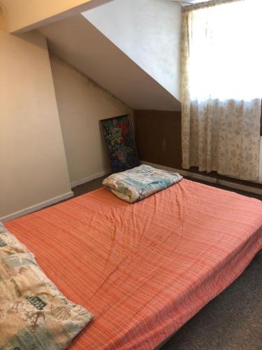 a bedroom with a large orange bed with a window at Soho Accommodation in Newry