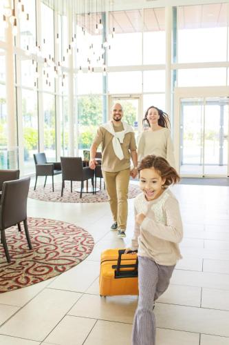 a family walking through a hotel lobby with a little girl at Hilton Garden Inn Sunderland in Sunderland