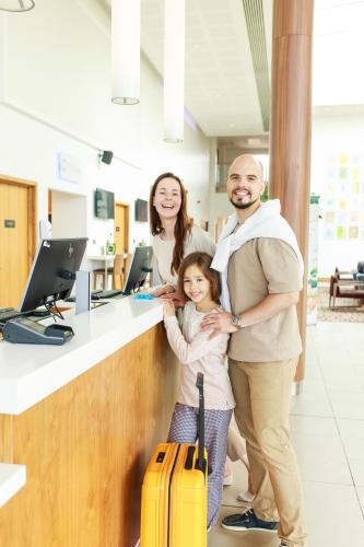a family standing in front of a counter with luggage at Hilton Garden Inn Sunderland in Sunderland