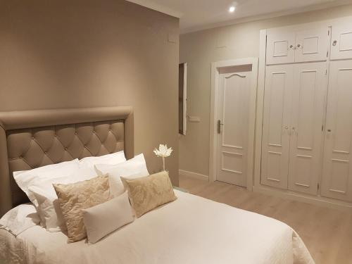 a bedroom with a bed with white sheets and pillows at Apartamento GranVía4 Parking free in Granada
