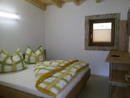 RangersdorfにあるKlenig Hofのベッドルーム1室(黄色と緑の枕が付いたベッド1台付)