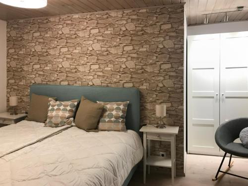 a bedroom with a bed and a stone wall at Bergromantik Ferienwohnung Charme mit einer Infrarotkabine und Bergblick in Marktschellenberg
