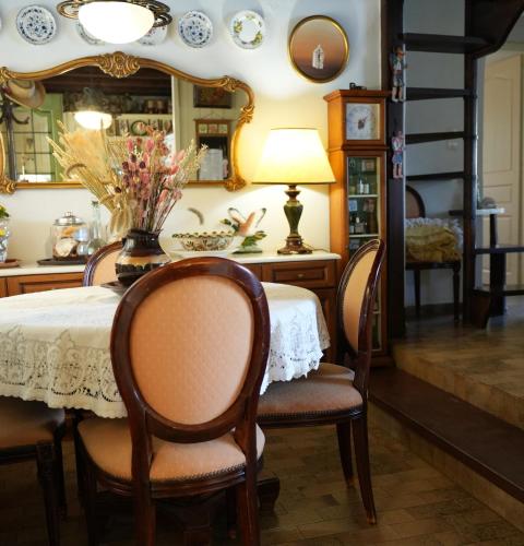 a dining room with a table with chairs and a mirror at Aphrodite's Coast Retreat House! in Galaxidi