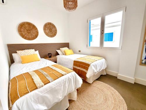 a bedroom with two beds and a window at Famara ocean view house in Famara
