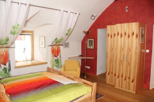 グミュント・イン・ケルンテンにあるFerienwohnung Vorstadtの赤い壁のベッドルーム1室(ベッド1台付)