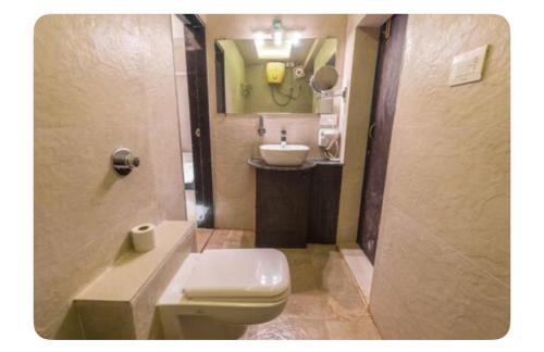 a bathroom with a white toilet and a sink at Avis Home in Calangute