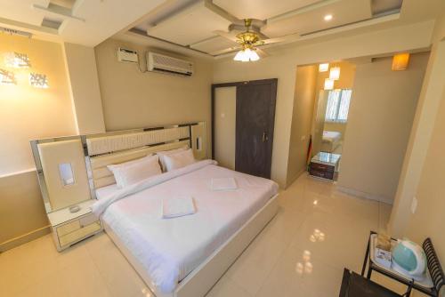 a bedroom with a large white bed with two books on it at Avis Home in Calangute