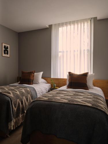 two beds in a room with a window at The Marloes in London
