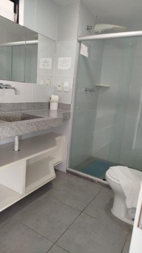 a bathroom with a glass shower and a toilet at Atlântico Hotel Maceió in Maceió