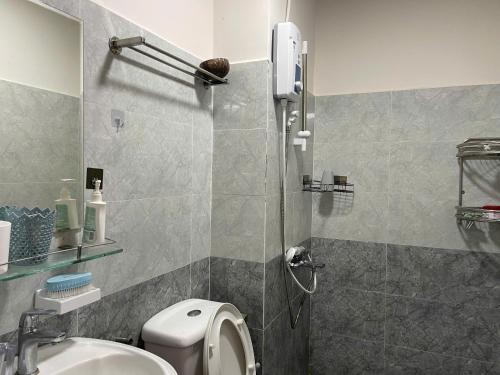 a bathroom with a shower with a toilet and a sink at Coral Homestay Phan Rang in Kinh Dinh