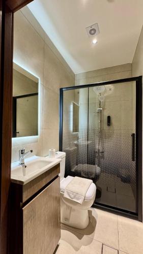 a bathroom with a shower and a toilet and a sink at Antika Amman Hotel in Amman