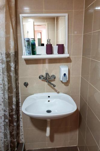 a white sink in a bathroom with a mirror at Kapija Grada in Ečka