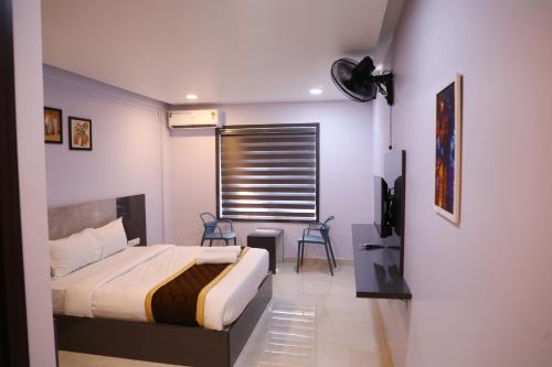 a bedroom with a bed and a window with a fan at Elara Residency Cheravathur in Cheruvattūr
