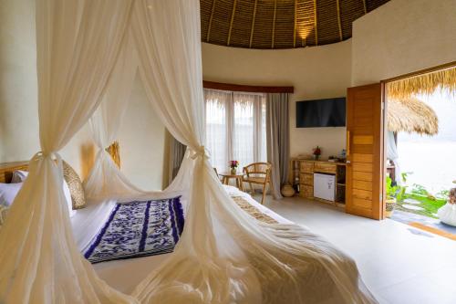 a bedroom with a bed with a mosquito net at Santhi Loka in Kubupenlokan
