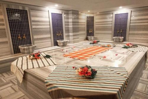 a swimming pool with two tables in a room at Elit Life Otel - All Inclusive in Kemer