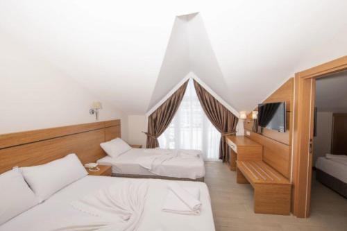 a hotel room with two beds and a television at Elit Life Otel - All Inclusive in Kemer