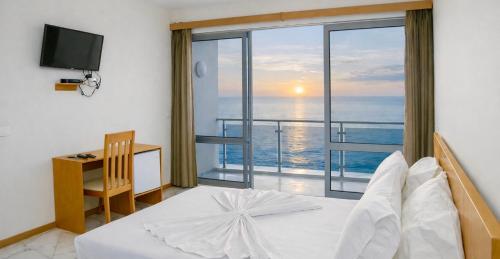 a bedroom with a bed and a view of the ocean at Cruzeiro Guest House in São Filipe