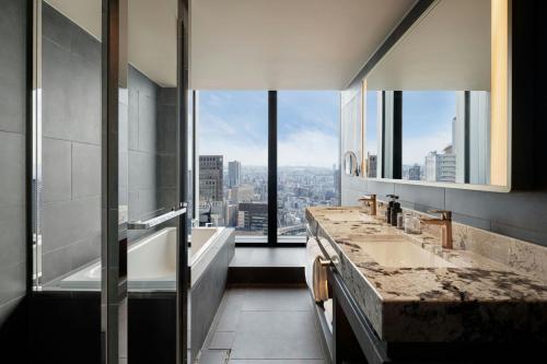 a bathroom with a tub and a sink and a window at THE OSAKA STATION HOTEL, Autograph Collection in Osaka