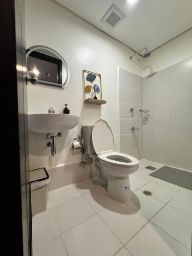 a bathroom with a toilet and a sink at JI Homestaycation in Manila