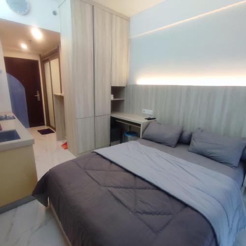 a bedroom with a large bed and a desk at Sky House BSD Apartment by Casanova in Cilenggang
