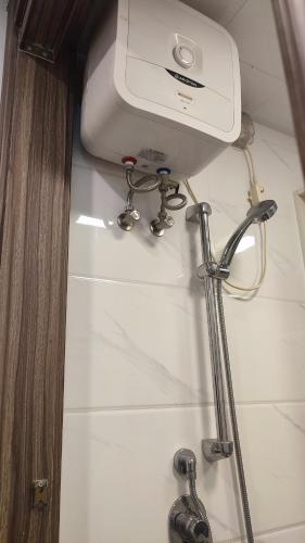 a toilet in a bathroom with a tank and two brushes at Sky House BSD Apartment by Casanova in Cilenggang