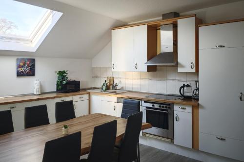 a kitchen with white cabinets and a wooden table at Gemeinschaftswohnung mit privaten Zimmern in Diepholz