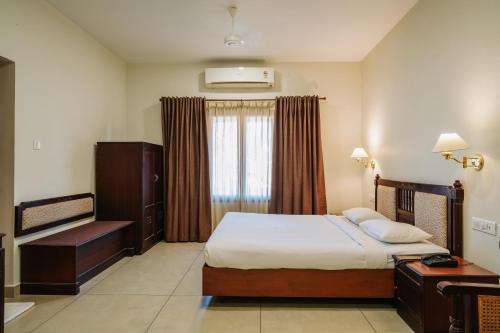 a hotel room with a bed and a window at Silver Crest Resort in Thekkady